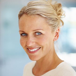 Blonder older woman smiling with bright teeth with Ramsey Dental Crowns.